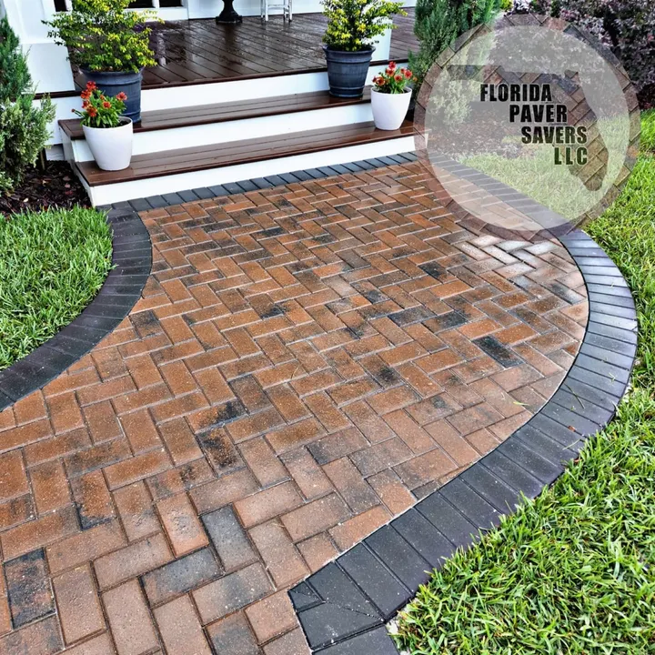 Curved brick paver entrance with a dark border leading to front steps