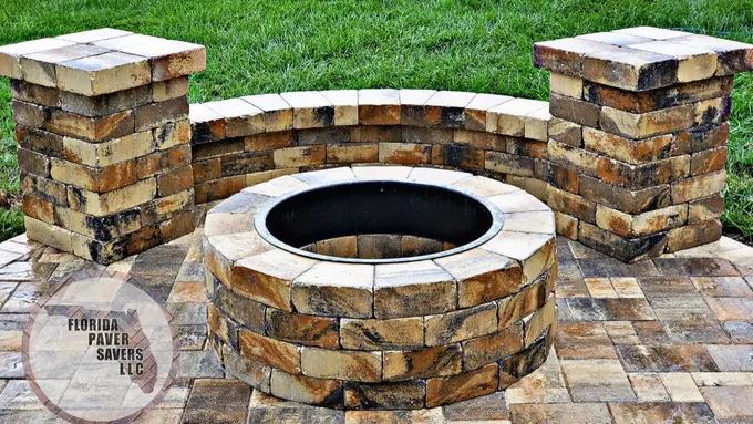 Close view of a circular fire pit, curved seating wall and square pillars