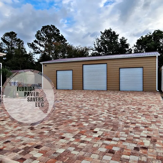 Red and cream paver approach in front of a three-door garage