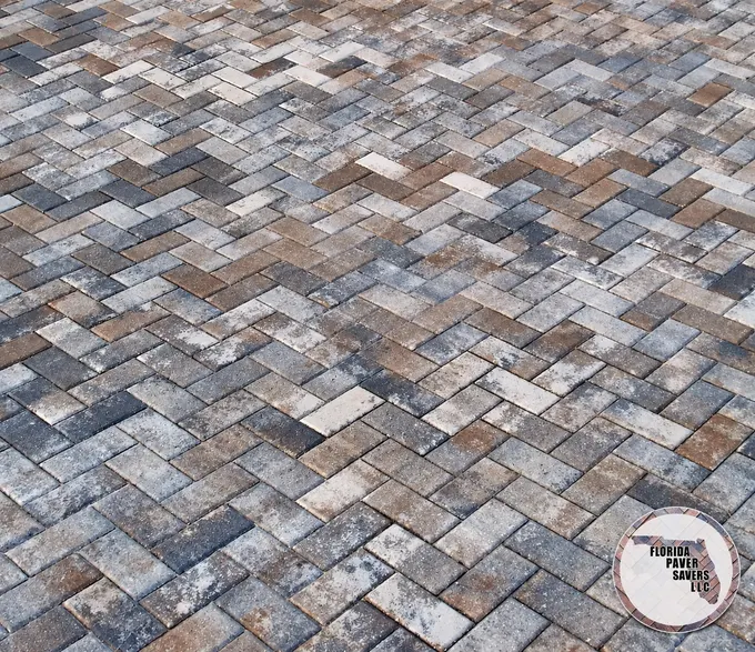 Close-up of gray and brown driveway pavers laid in a repeating pattern