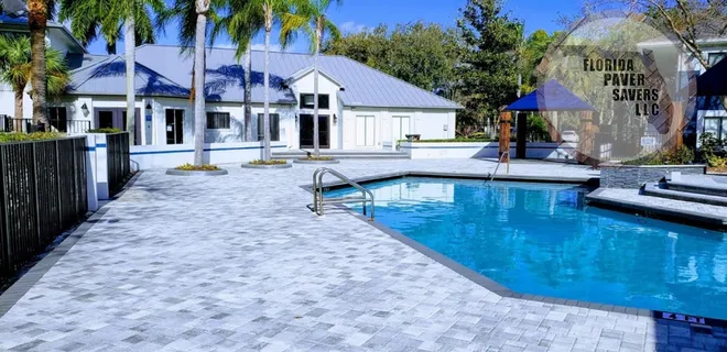 Paver pool deck surrounding a backyard swimming pool