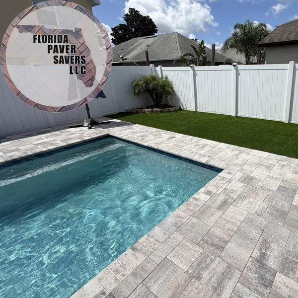 Artificial turf lawn beside a new gray paver pool deck in Spring Hill