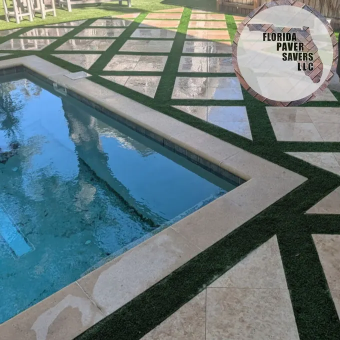 Geometric travertine and artificial turf design around a swimming pool