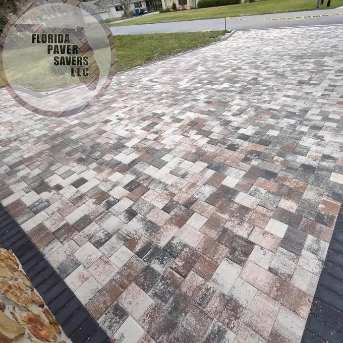 Close view of a multicolor paver driveway with contrasting dark edging