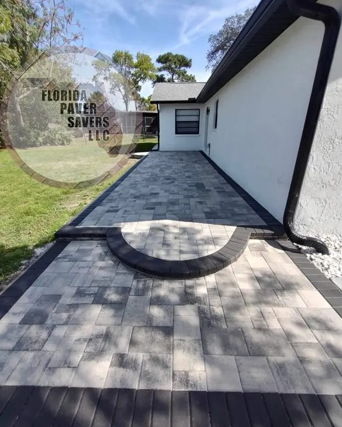 Paver patio along a home with a semicircular step at the doorway