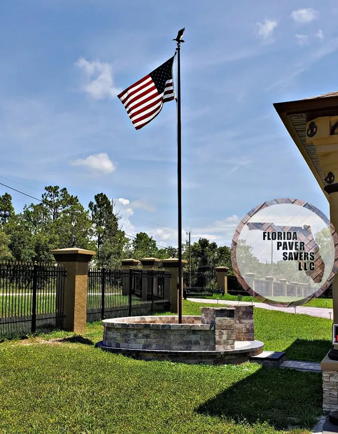 Curved stone seating wall and paver steps around a flagpole
