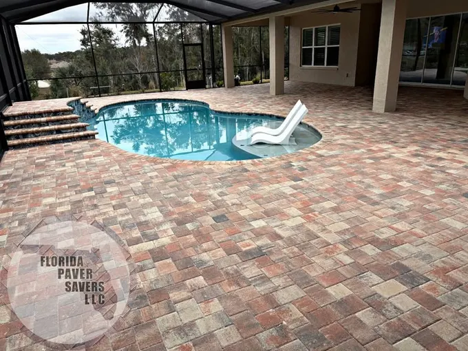 Multicolor paver pool deck with curved steps and a white slide