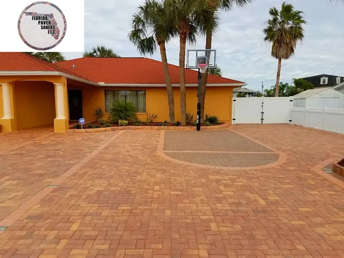 Red and tan paver driveway with a circular accent in front of an orange-roofed home