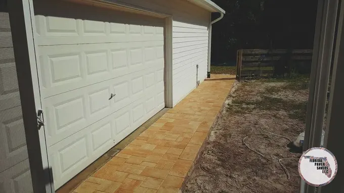 Tan paver path along the side of a detached garage