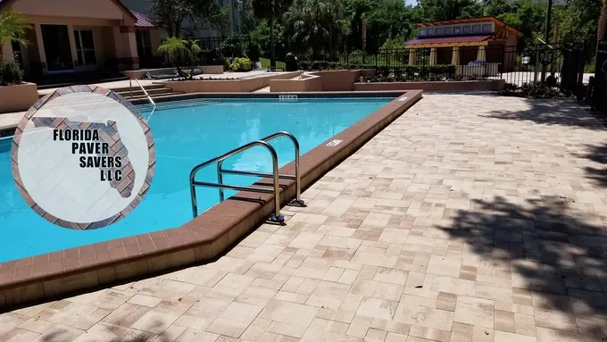 Commercial paver pool deck alongside swimming pool steps and a handrail