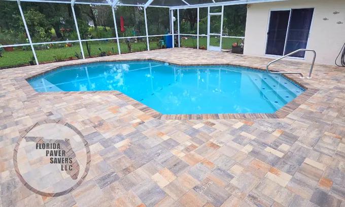 Multicolor paver pool deck with matching coping around a swimming pool inside a screened enclosure in Spring Hill, Hernando County, Florida